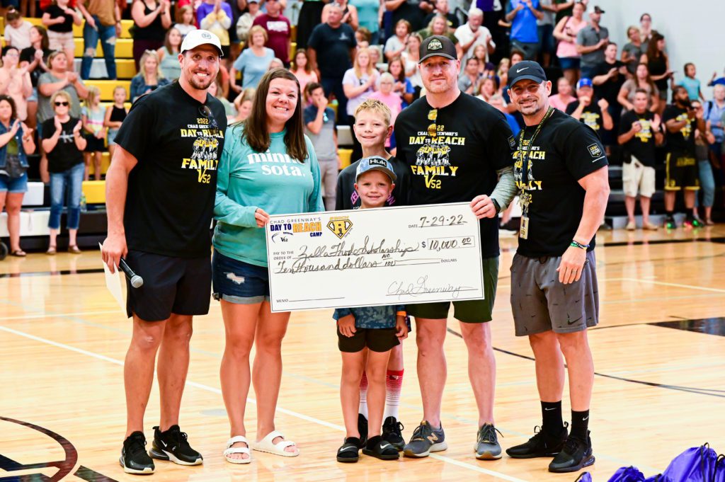 Family and Chad Greenway with check, smiling at camera.